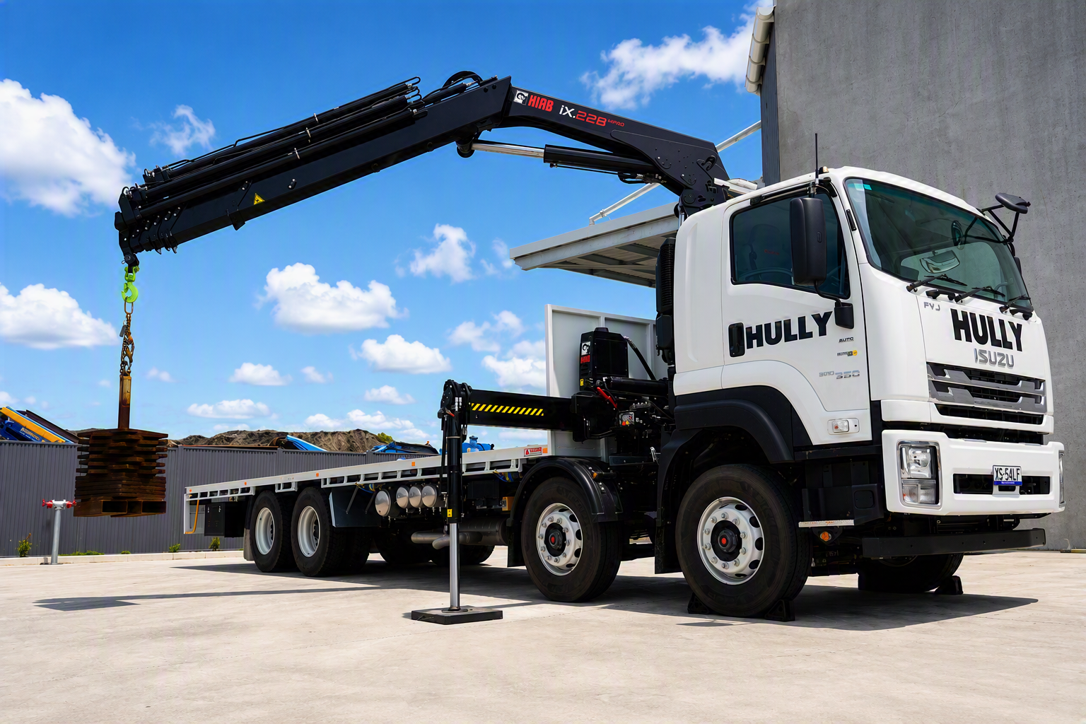 HIAB truck mounted crane lifting building materials to a construction site